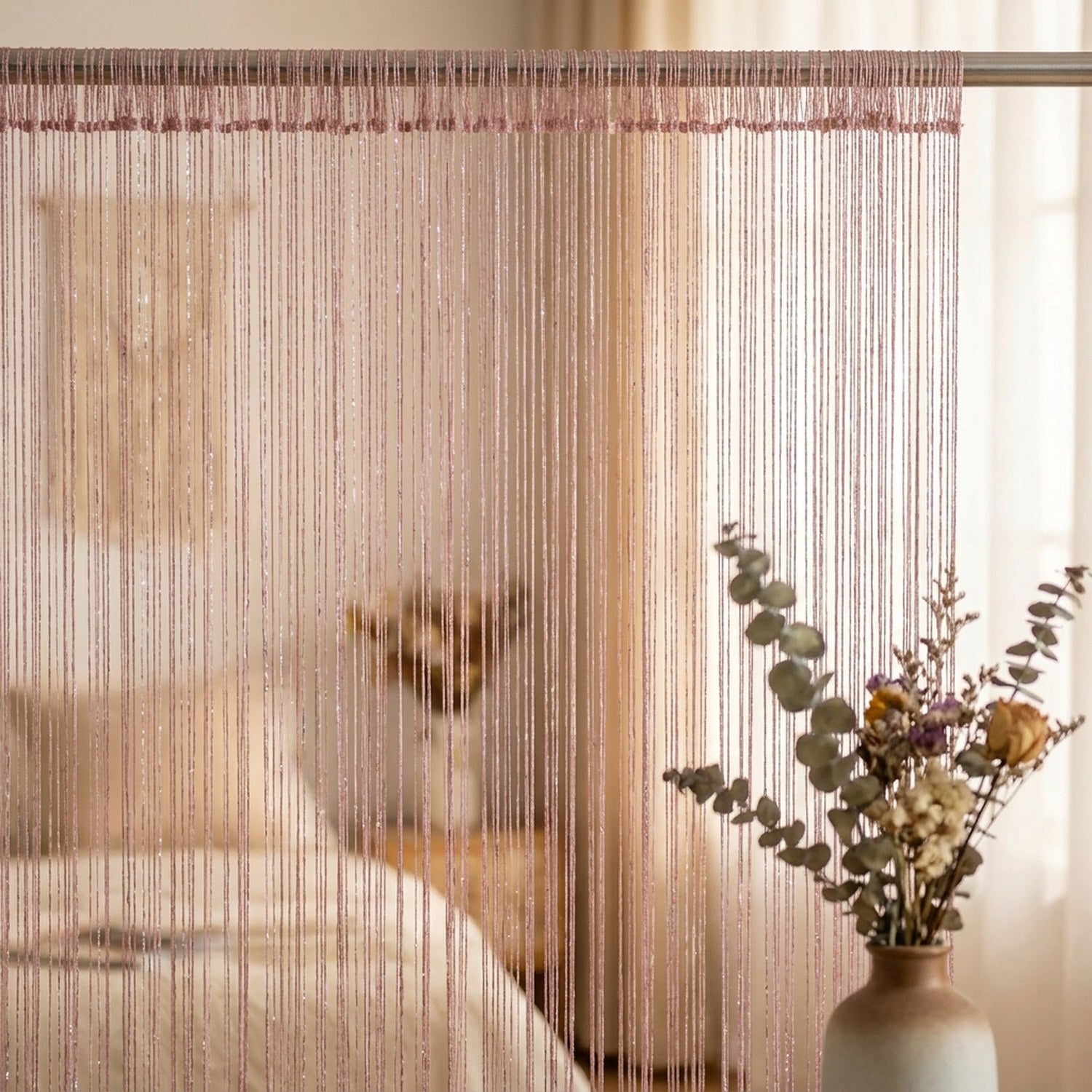 Rideau à fils pailleté rose poudré devant une fenêtre de chambre