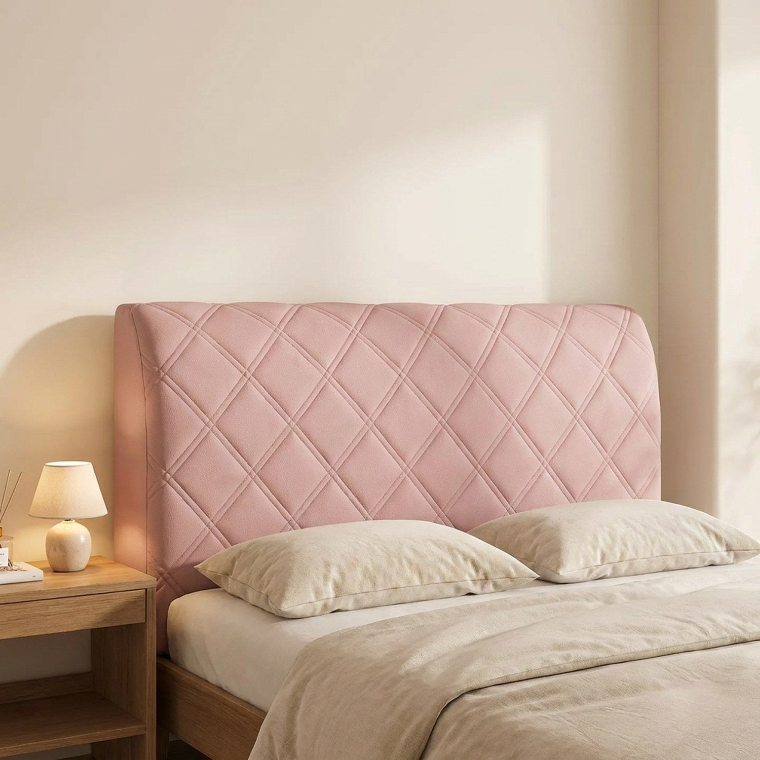 Housse de tête de lit couleur rose installée sur un lit avec lampe de chevet