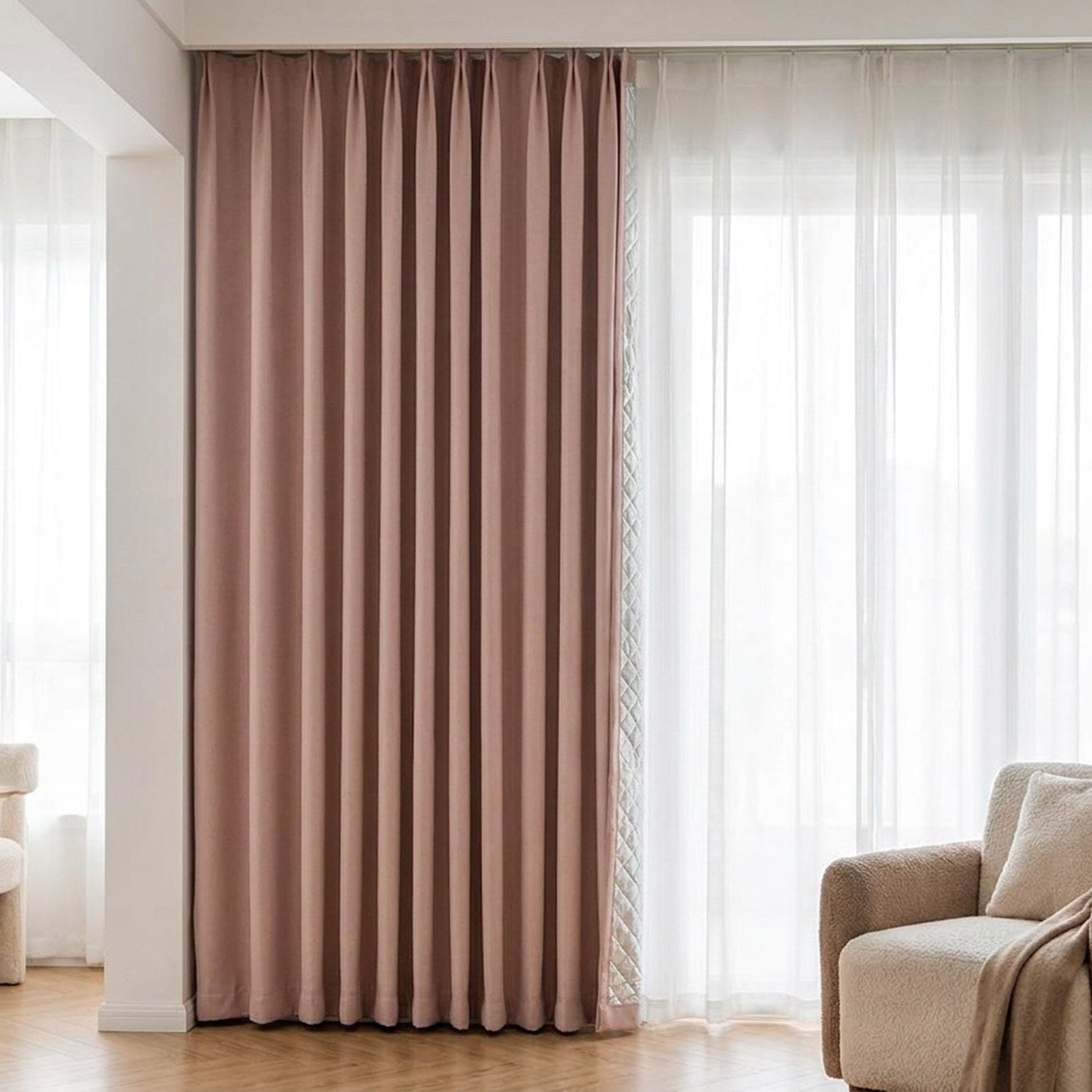 Rideau occultant rose poudré suspendu devant une fenêtre lumineuse avec canapé beige