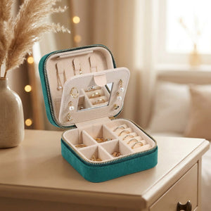 Boîte à bijoux de voyage en velours vert ouverte avec miroir et rangements