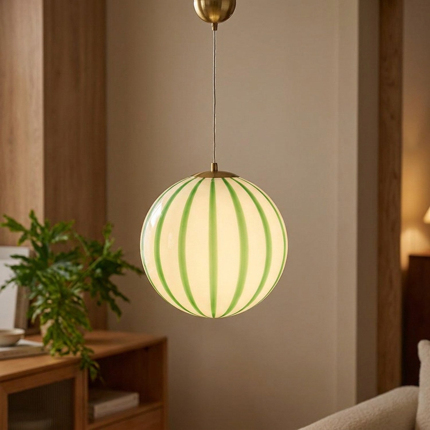 Suspension boule en verre rayée de vert allumée
