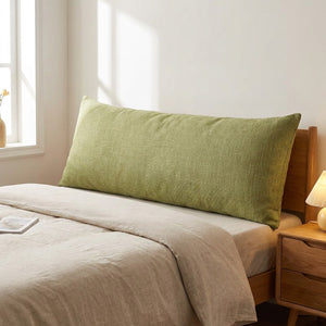 Housse de coussin longue en coton et lin vert sauge sur un lit