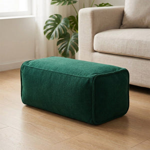 Pouf repose-pieds en chenille vert foncé près d'un canapé en lin