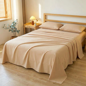 Drap plat beige en coton pur fait sur un lit