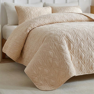 Couvre-lit matelassé beige gros plan sur le motif losange