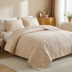 Couvre-lit matelassé beige avec taies d'oreiller sur un lit