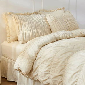Parure de lit bohème chic beige avec taies froissées sur un lit fait