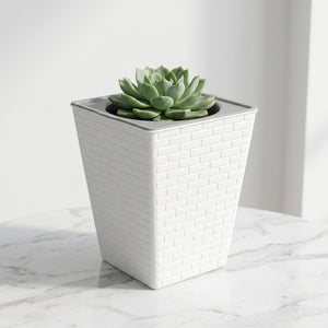 Jardinière carrée blanche texture brique avec succulente sur marbre blanc