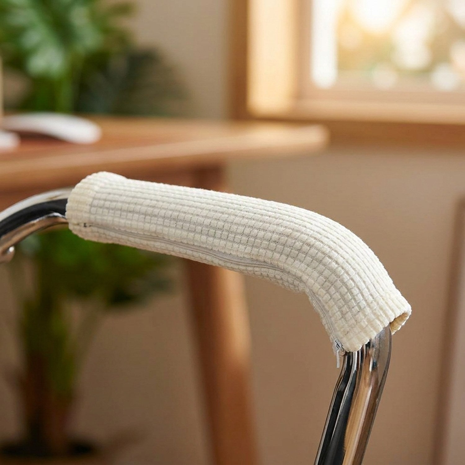 Housse d'accoudoir blanche sur l'accoudoir chromé d'une chaise de bureau