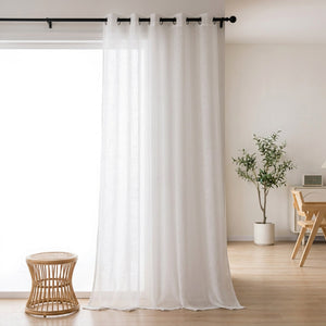Voilage tulle blanc transparent suspendu à une tringle dans un salon lumineux et épuré