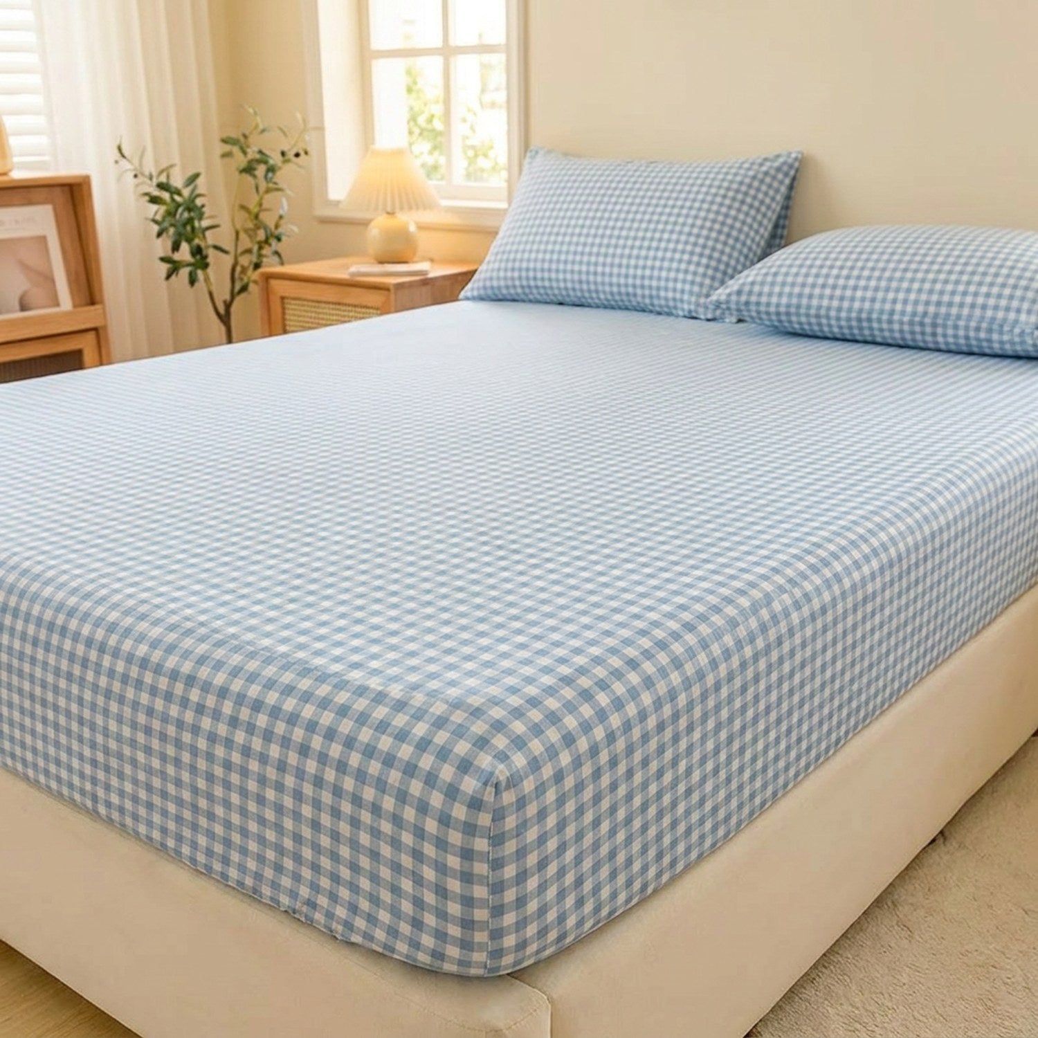 Drap-housse à carreaux bleu installé sur un lit fait dans une chambre chaleureuse