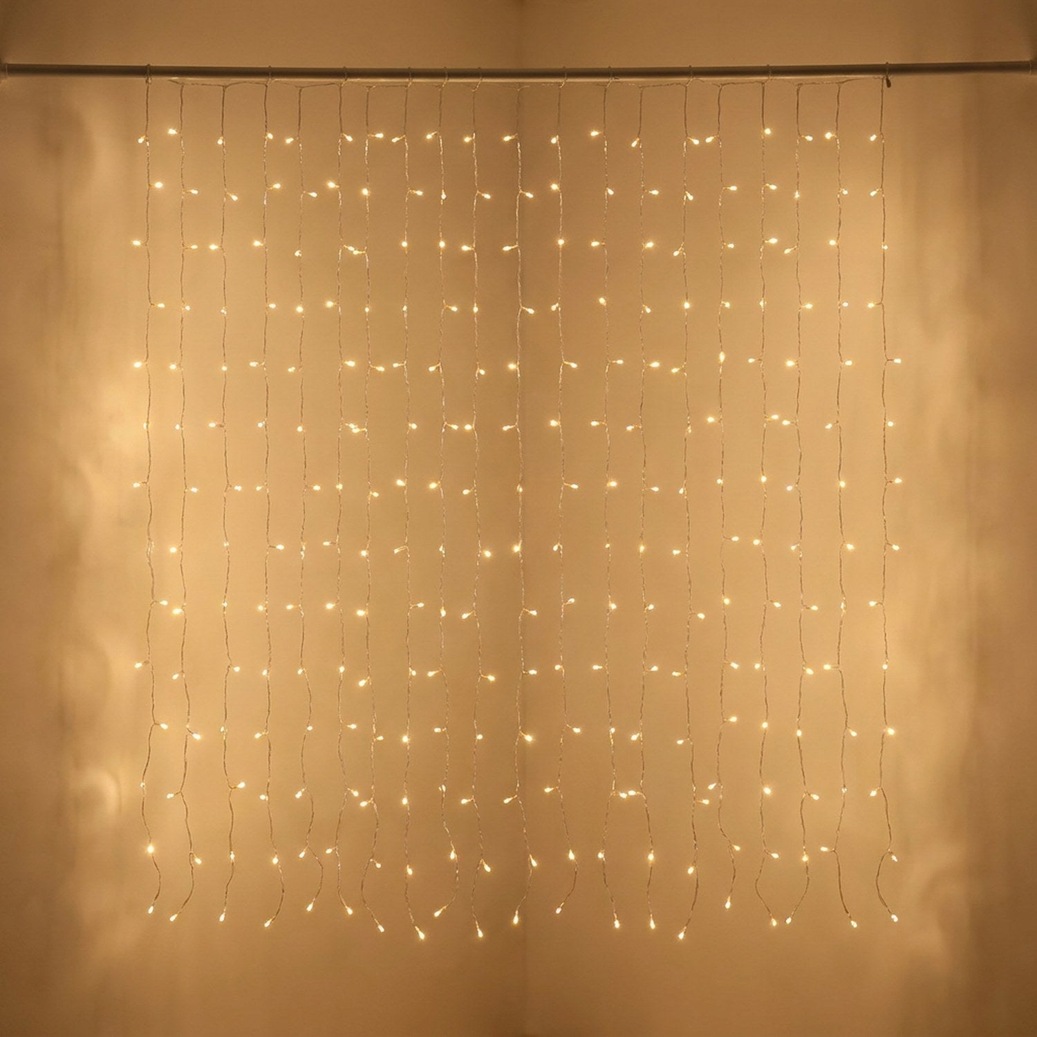 Rideau lumineux LED couleur dorée en gros plan suspendu à une tringle