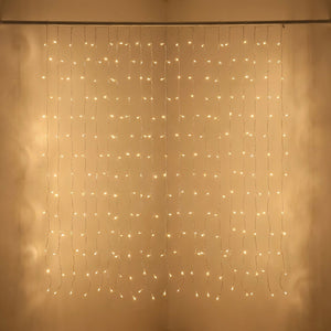 Rideau lumineux LED couleur dorée en gros plan suspendu à une tringle