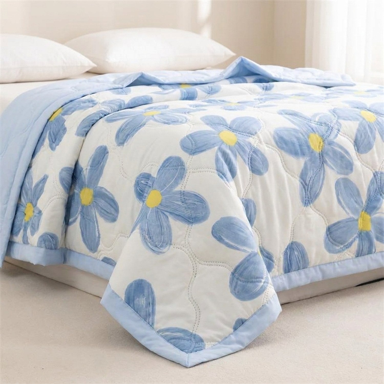 Couverture été motif fleurs bleues gros plan sur le coin du lit