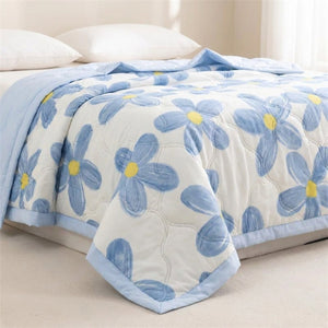 Couverture été motif fleurs bleues gros plan sur le coin du lit