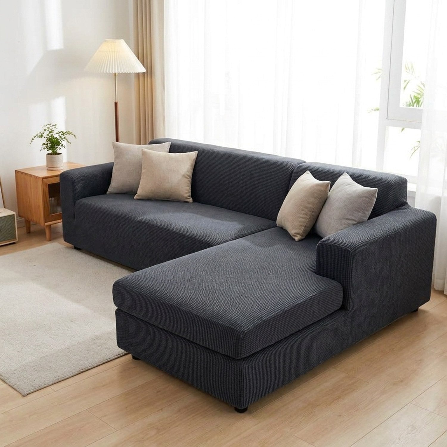 Housse de canapé extensible gris anthracite installée sur un canapé d'angle