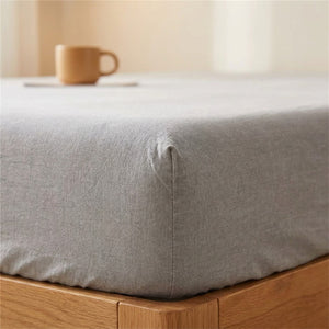 Coin du drap housse gris uni bien ajuste sur le matelas