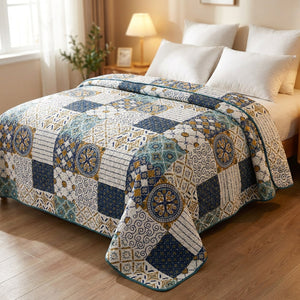 Couvre-lit matelassé motif patchwork bleu marine et or sur un lit