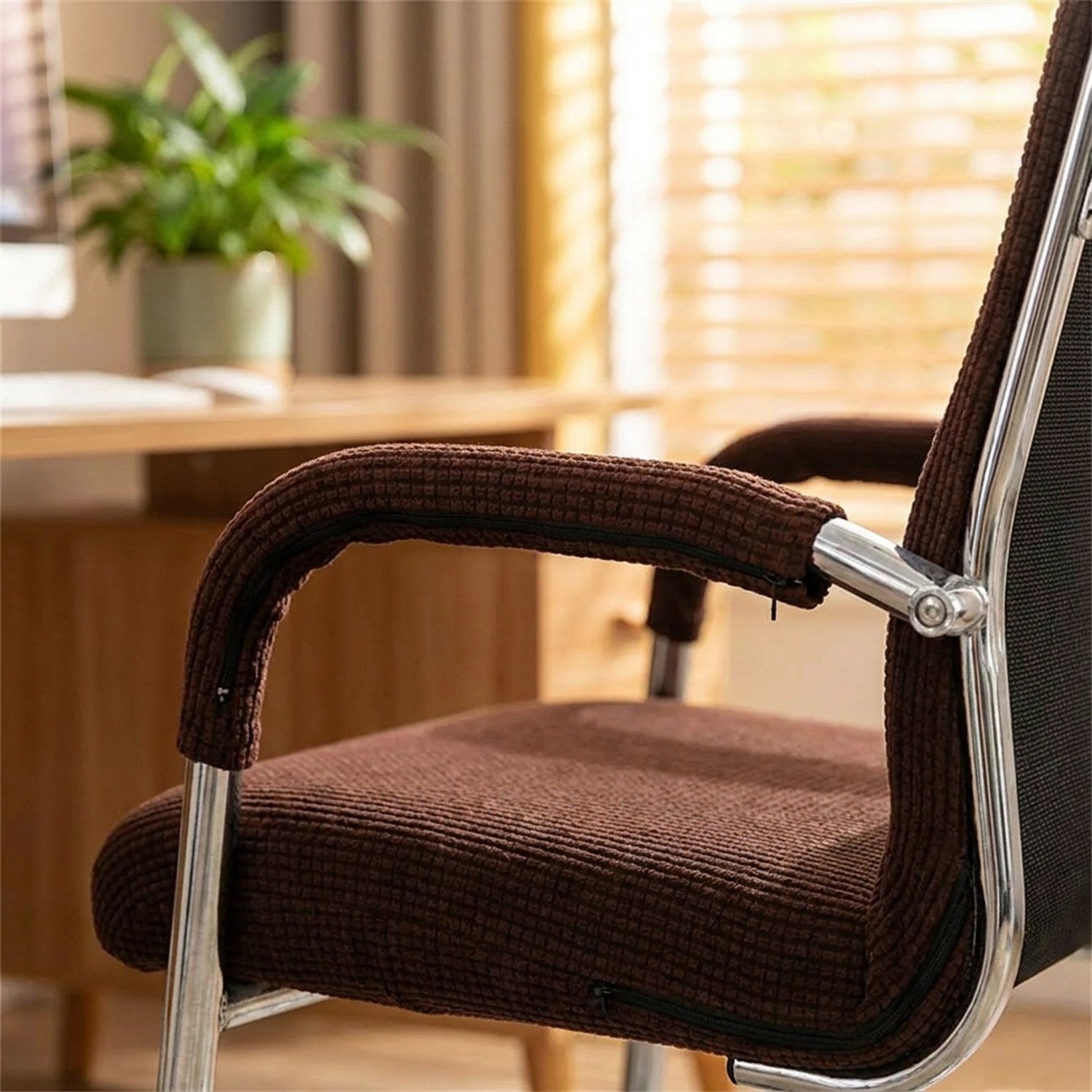 Housse d'accoudoir marron sur l'accoudoir chromé d'une chaise de bureau
