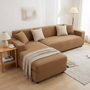 Housse de canapé extensible marron installée sur un canapé d'angle