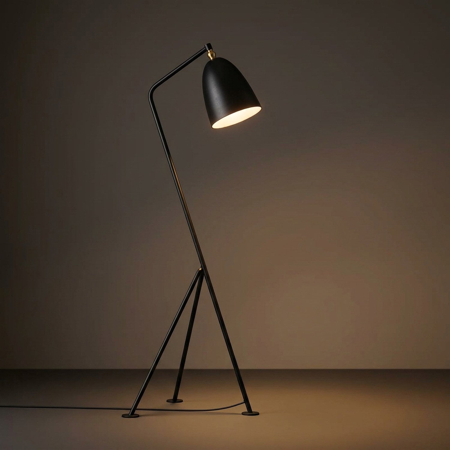 Lampadaire trépied noir sur fond neutre mettant en valeur son design scandinave