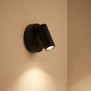 Applique murale LED noire vue de près allumée sur mur clair