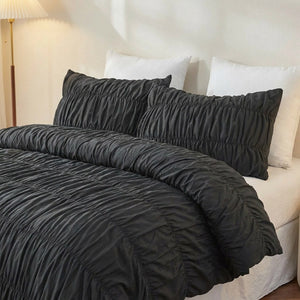 Parure de lit bohème chic noire avec taies froissées sur un lit fait