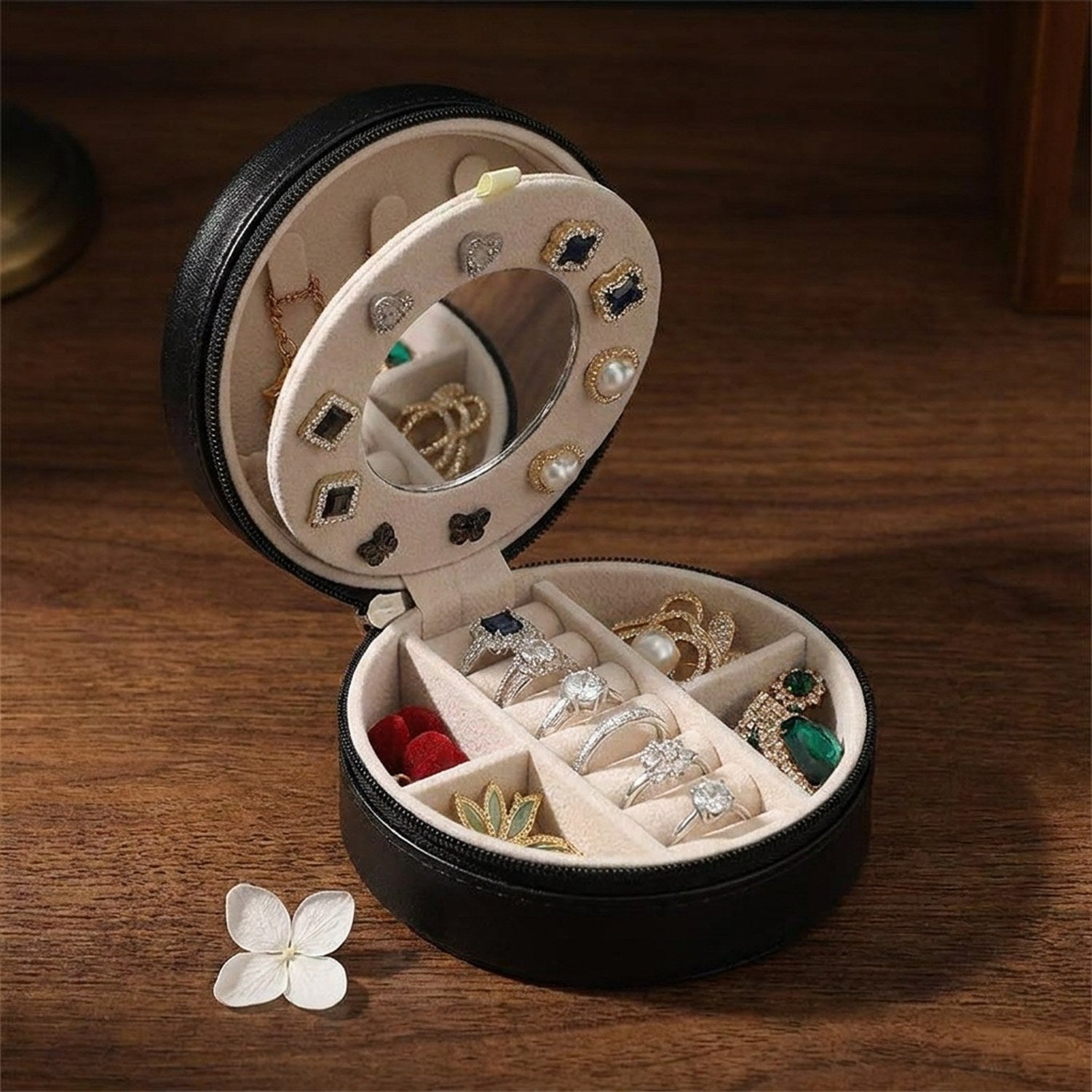 Coffret à bijoux de voyage noire ouvert sur bois montrant miroir et compartiments velours