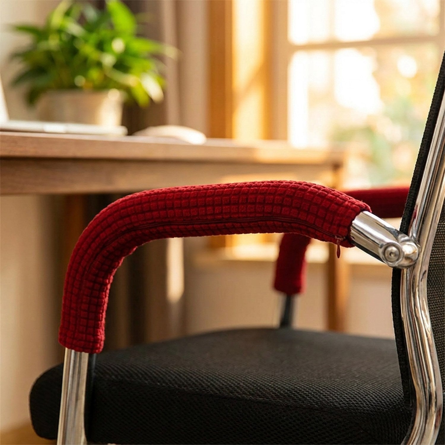 Housse d'accoudoir rouge sur l'accoudoir chromé d'une chaise de bureau