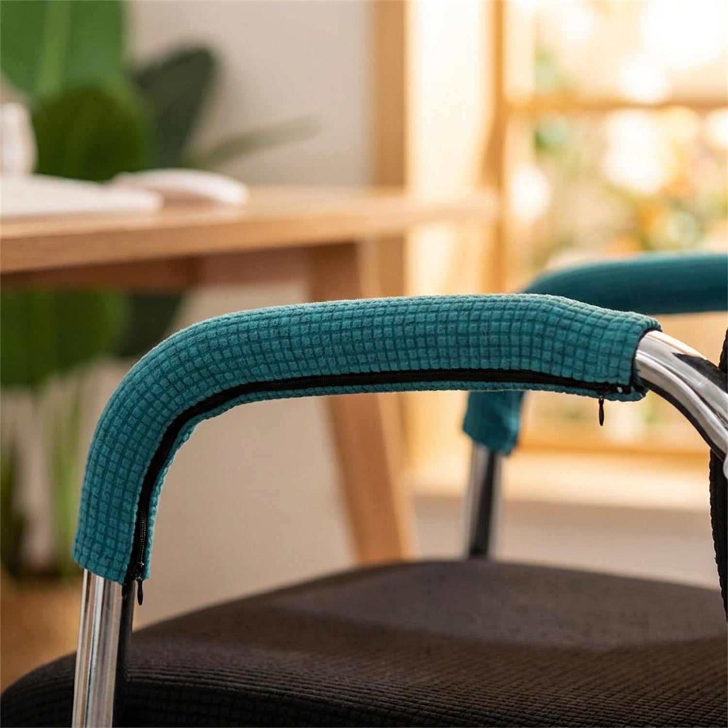 Housse d'accoudoir turquoise sur l'accoudoir chromé d'une chaise de bureau