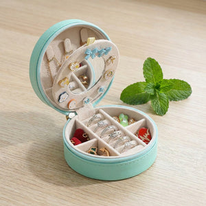 Coffret à bijoux de voyage turquoise ouvert avec miroir et bijoux colorés