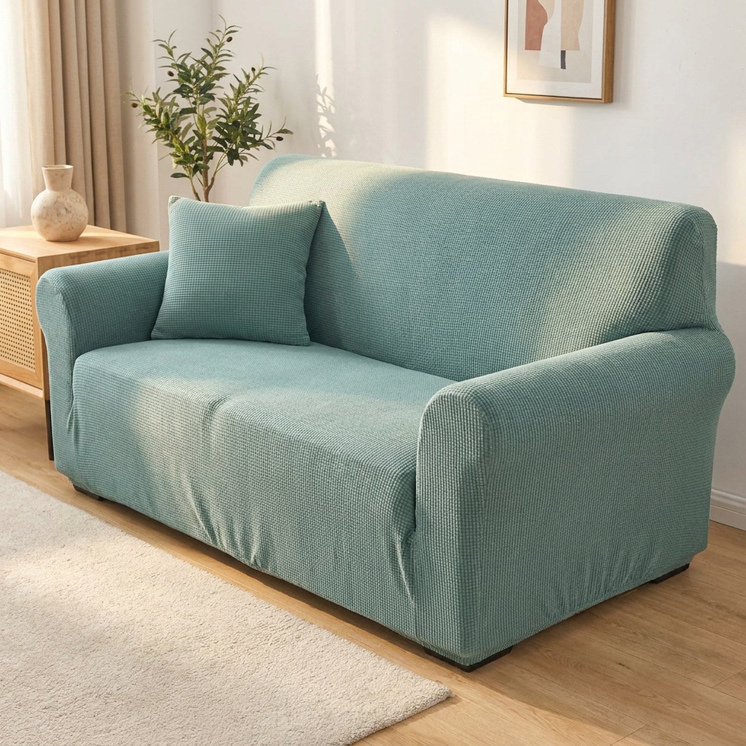 Housse de canapé turquoise en velours installée sur un canapé