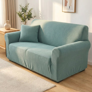 Housse de canapé turquoise en velours installée sur un canapé