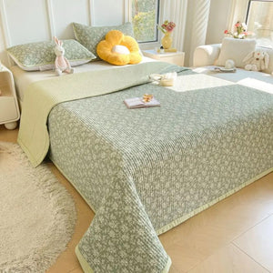 Couvre-lit matelassé coloris vert clair motifs floraux sur un lit