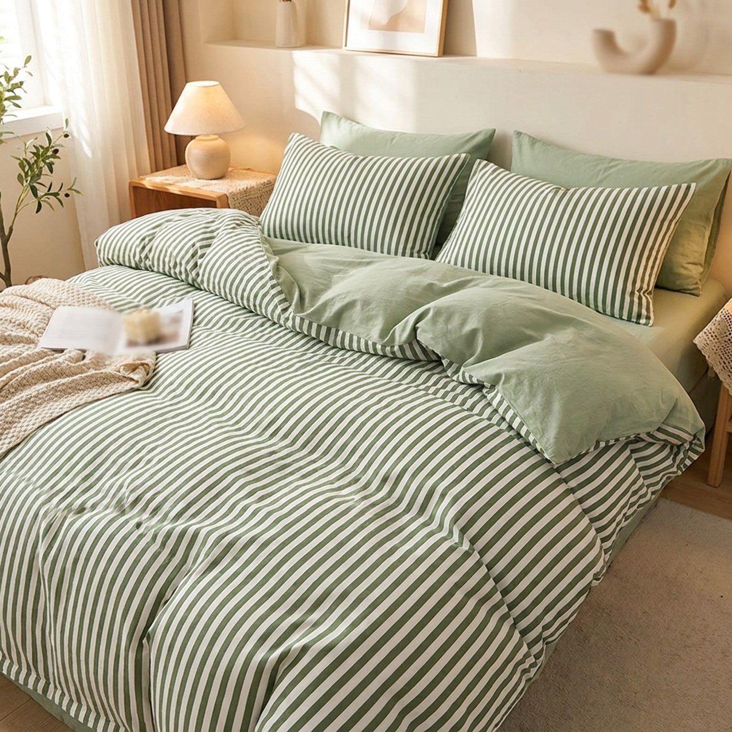 Housse de couette rayee verte et blanche posee sur un lit fait dans une chambre lumineuse