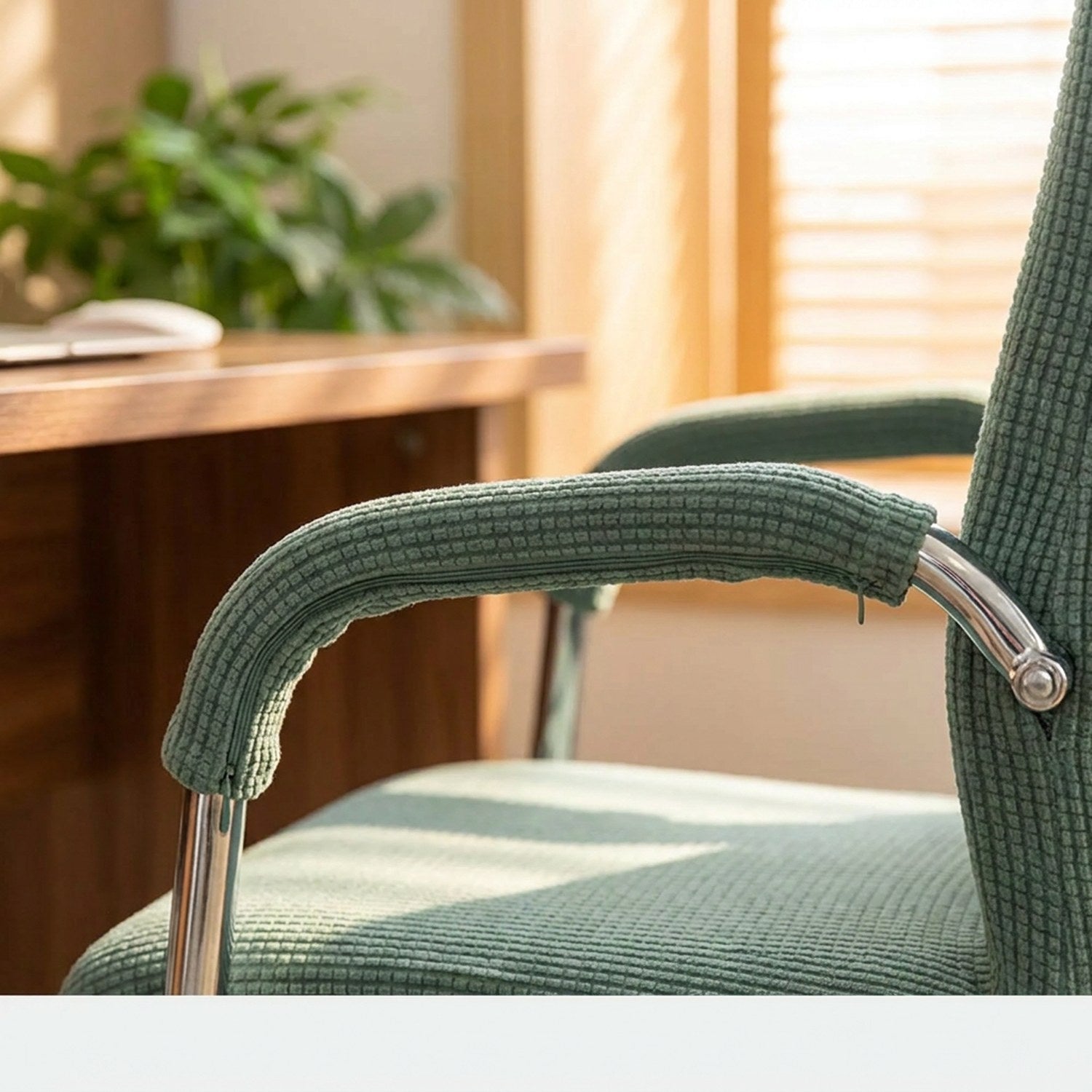 Housse d'accoudoir verte sur l'accoudoir chromé d'une chaise de bureau