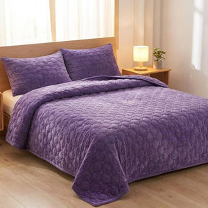 Couvre-lit matelassé violet avec taies assorties sur un lit