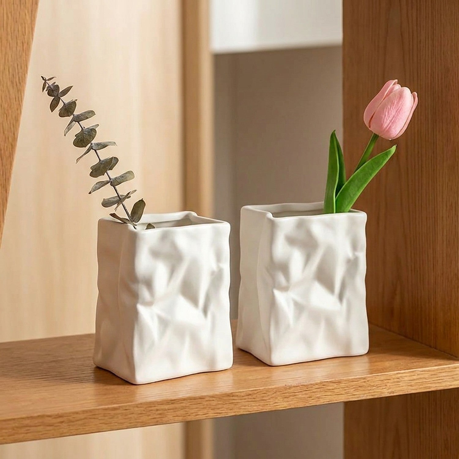Lot de 2 vases froissés blancs côte à côte avec fleurs sur étagère bois