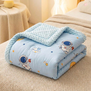 Couette bébé motif astronaute repliée montrant le tissu doux