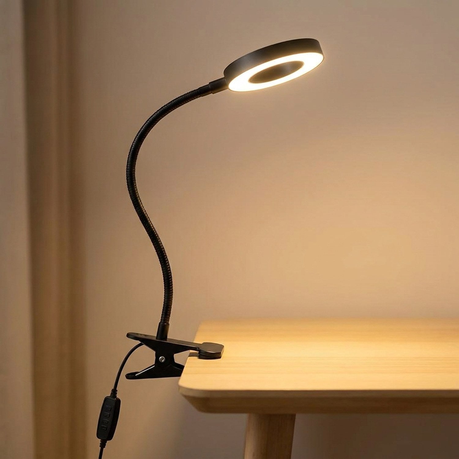 Lampe de bureau à pince noire avec bras flexible col de cygne allumée