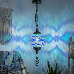 Suspension mosaïque Bleu allumée diffusant une lumière turquoise sur les murs