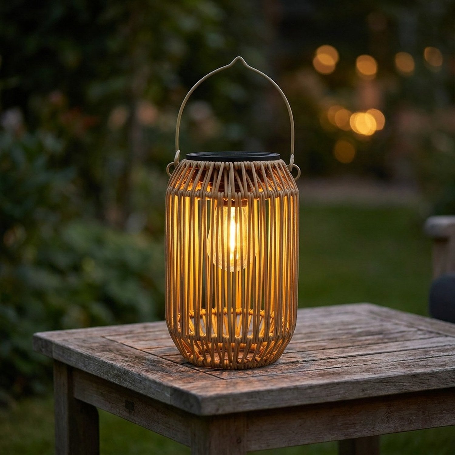 Lanterne solaire en bambou tressé forme cylindrique posée sur une table en bois