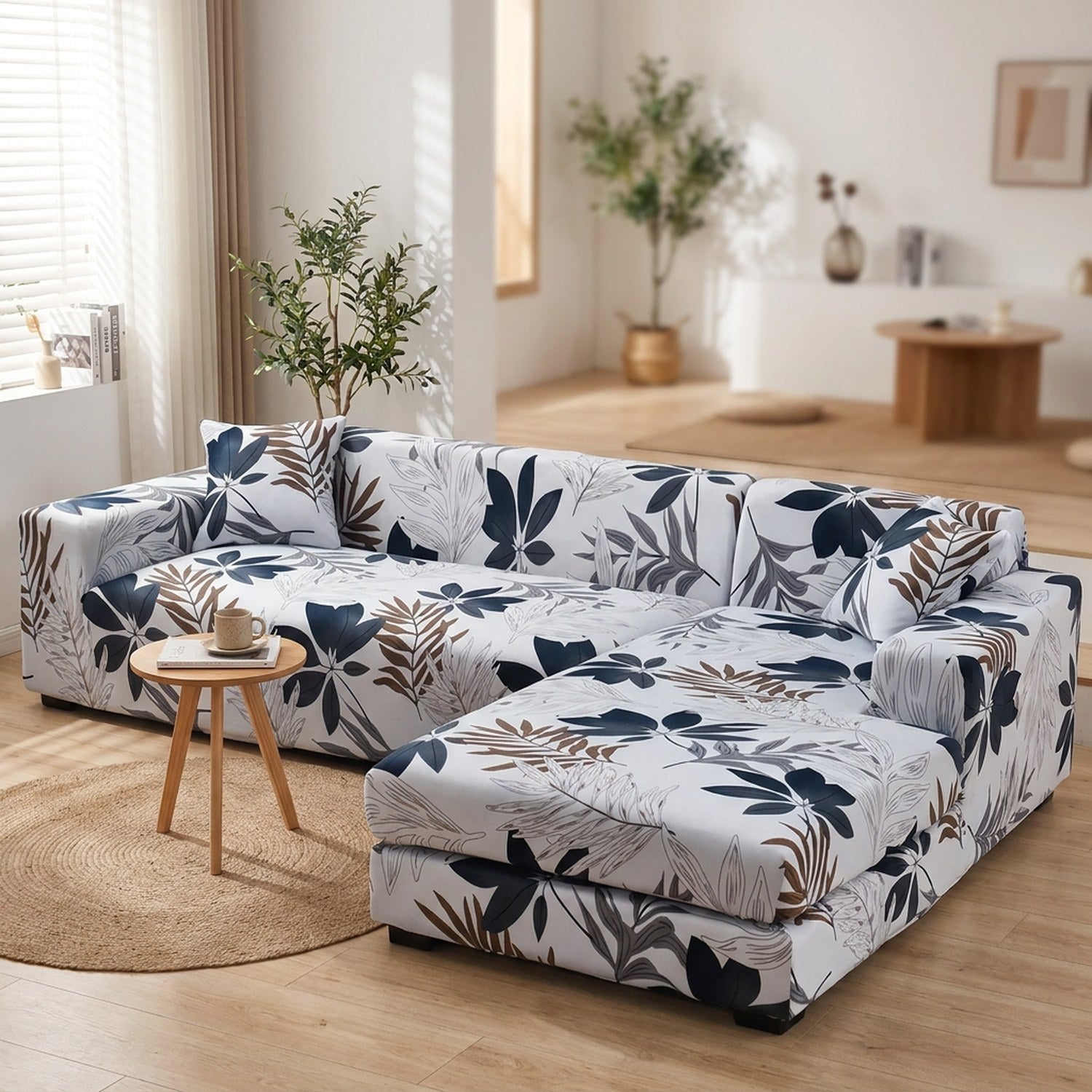 Housse de canapé d'angle motif feuillage blanc et bleu marine dans un salon lumineux