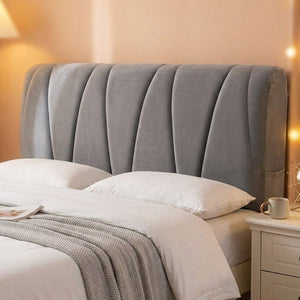 Housse de tête de lit grise capitonnée vue de face installée sur un lit