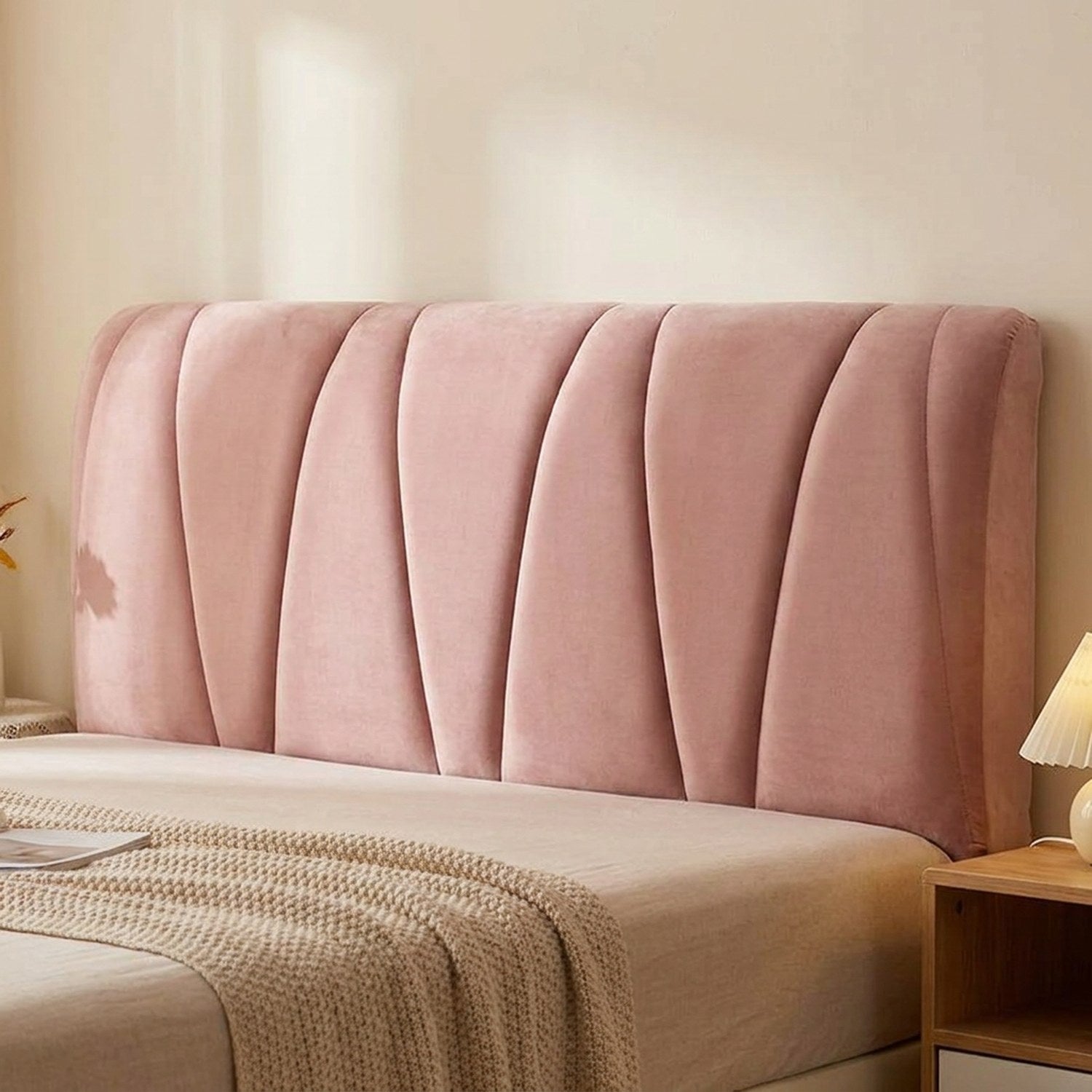 Housse de tête de lit rose capitonnée vue de face installée sur un lit