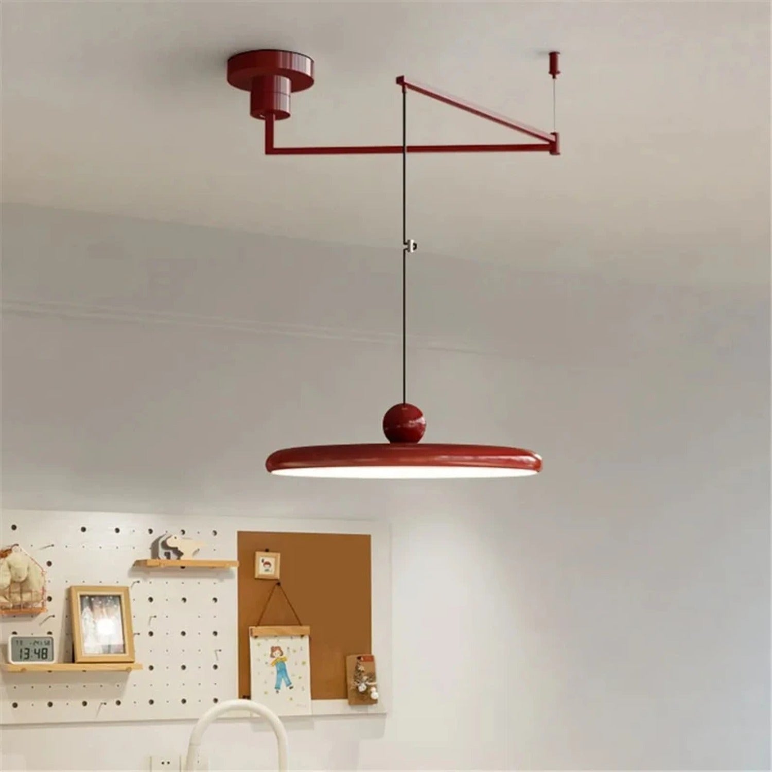 Suspension UFO rouge à bras oscillant dans décor bureau créatif moderne