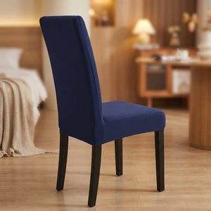 Housse de chaise bleu foncé extensible et imperméable sur une chaise de salle à manger