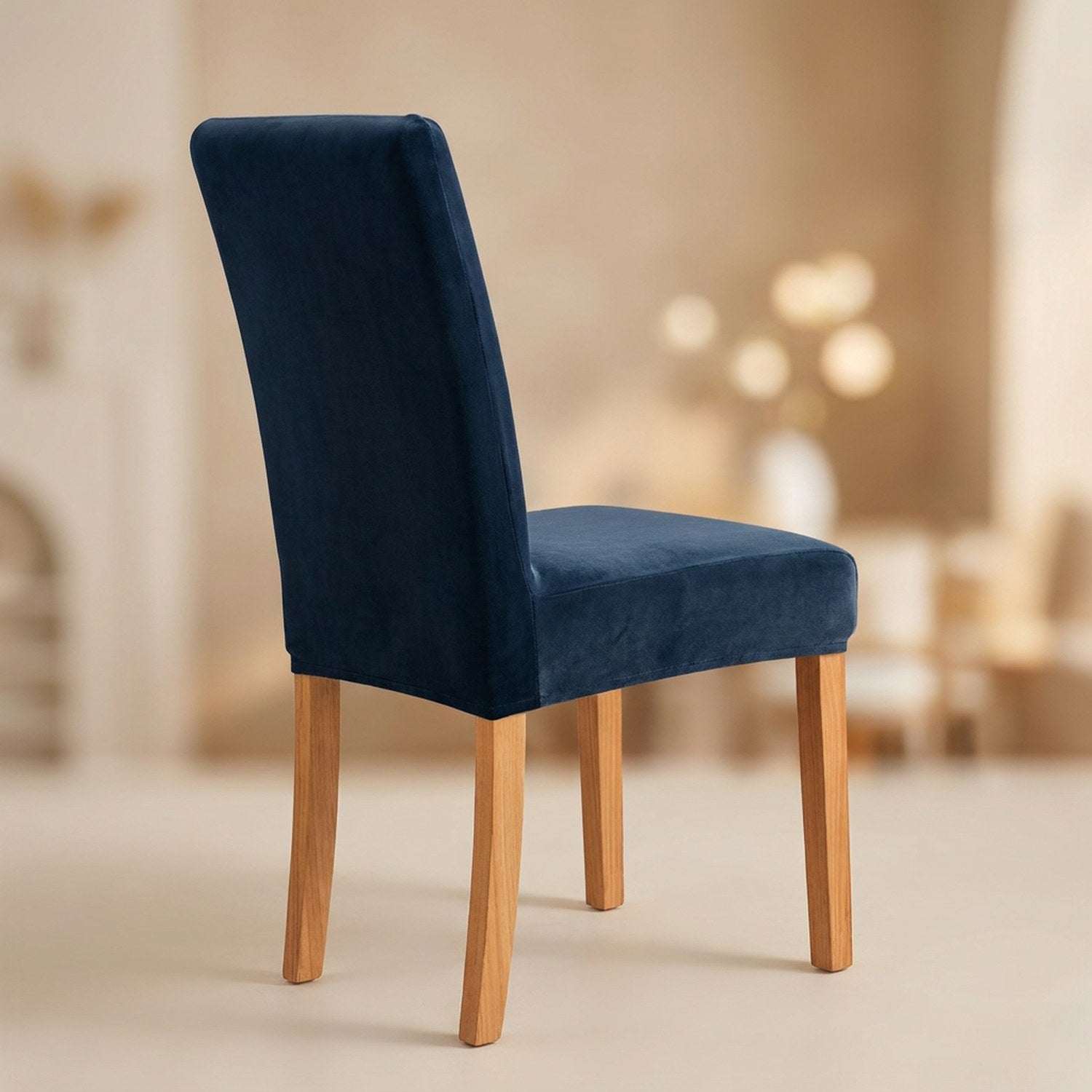 Housse de chaise bleu foncé en velours moelleux sur une chaise de salle à manger