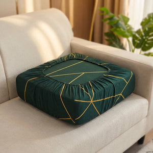 Housse de coussin de canapé vert émeraude à motifs dorés géométriques sur un canapé élégant