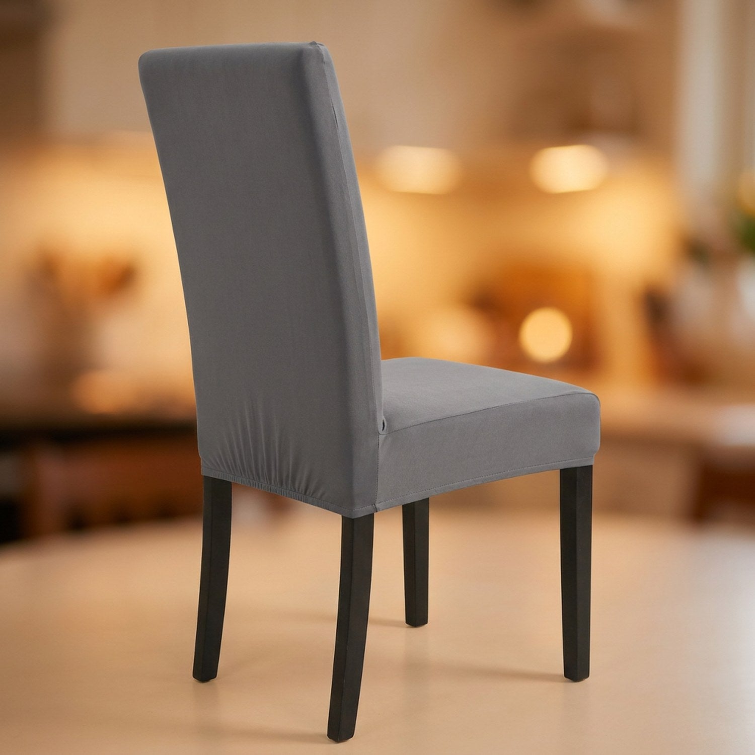 Housse de chaise grise extensible et imperméable sur une chaise de salle à manger